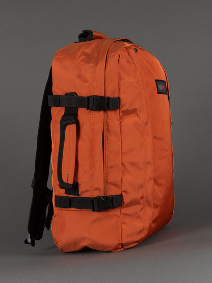 "Orange cabin-size travel backpack with padded laptop compartment"
