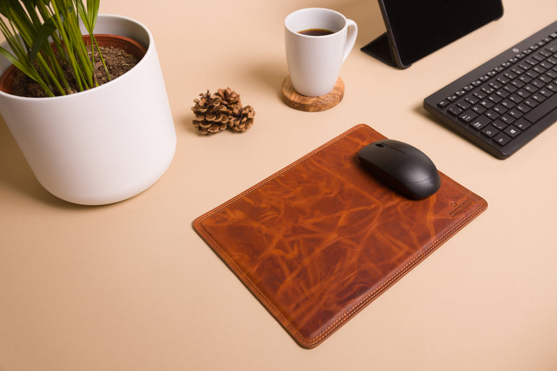 "Tan leather mouse mat with engraved initials"